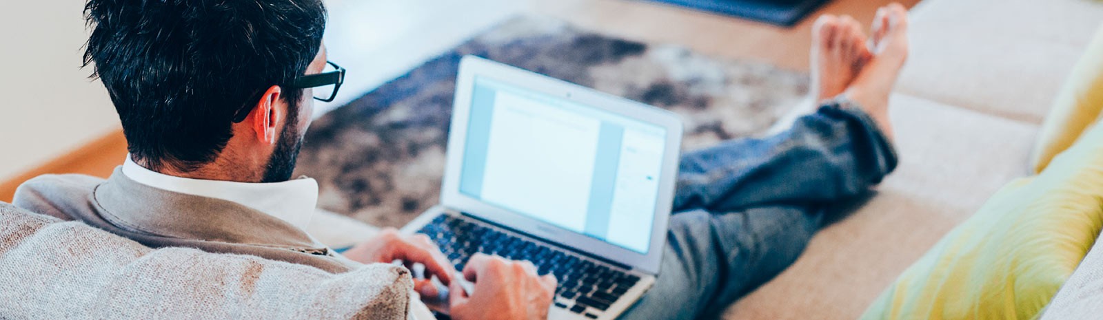 Man using laptop on couch.