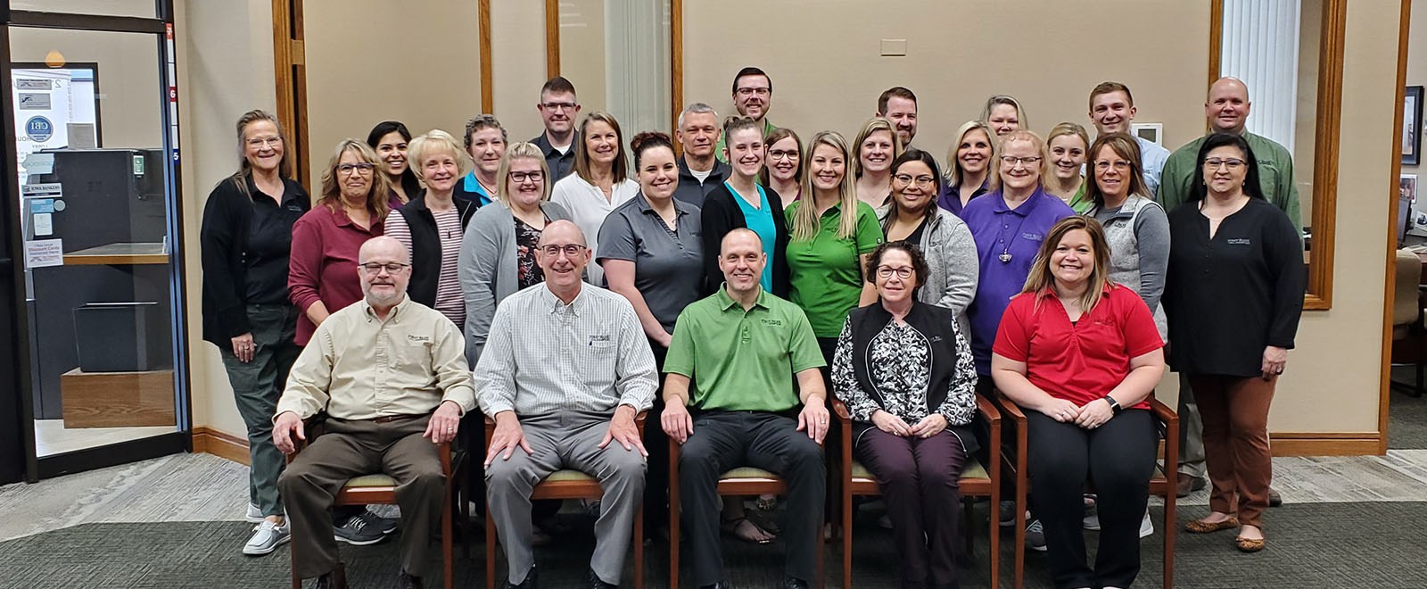 Large group of employees wearing bank attire.