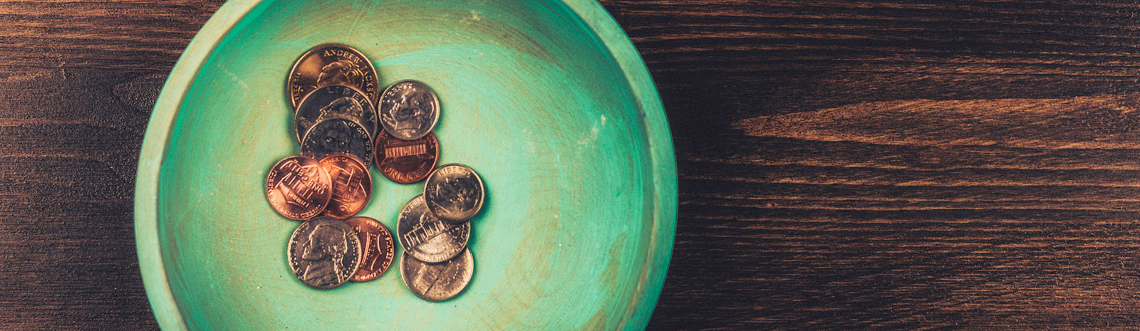 Coins in bowl on table.